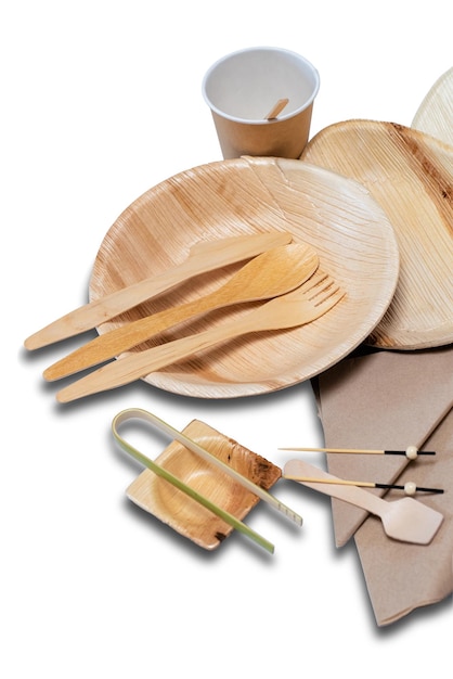 Utensílios de mesa e pratos e talheres descartáveis de bambu para piquenique no fundo branco.