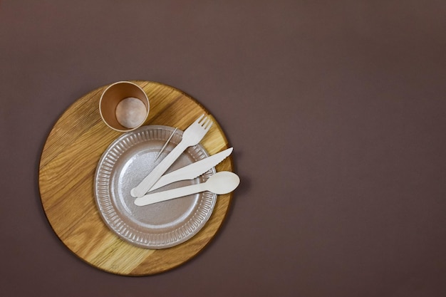 Utensílios de papelão descartáveis ambientalmente amigáveis com zero desperdício em um fundo marrom Lugar para uma inscrição Vista de cima