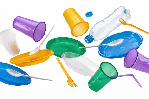 Foto utensílios de plástico multicoloridos voadores, isolados em um fundo branco. o conceito de ecologia.