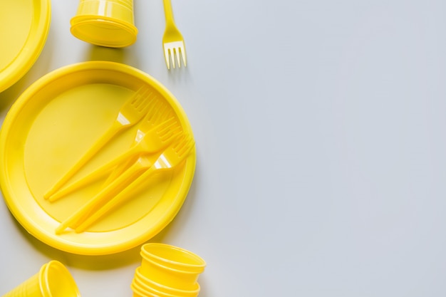 Foto utensilios de picnic amarillo de un solo uso para reciclar en gris.
