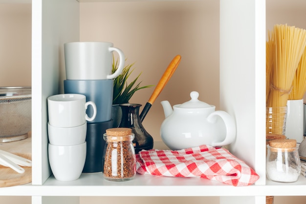 Utensilios y tazas, utensilios de cocina en estantes de madera