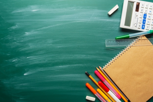 Útiles escolares sobre fondo de pizarra