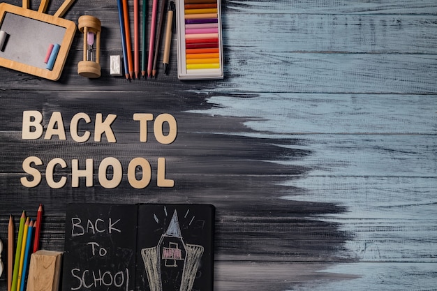 Foto Útiles escolares sobre fondo de tablero negro. concepto de regreso a la escuela.