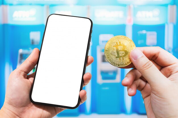 Utilice mano sosteniendo teléfono inteligente y moneda Bitcoin