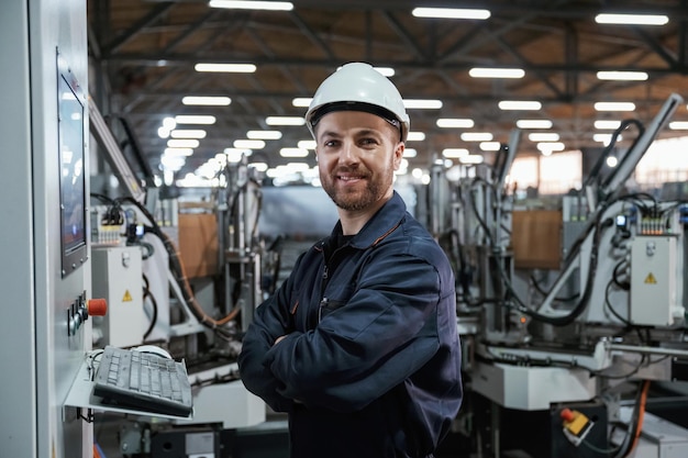 Utilizando o operador de equipamento O trabalhador da fábrica está dentro de casa com um capacete