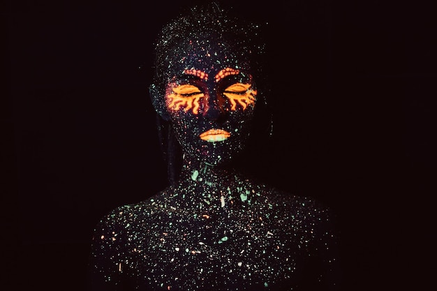 UV-Make-up. Porträt eines Mädchens in fluoreszierendem Pulver gemalt. Halloween-Konzept.