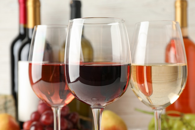 Uva, botellas y vasos con vino en blanco