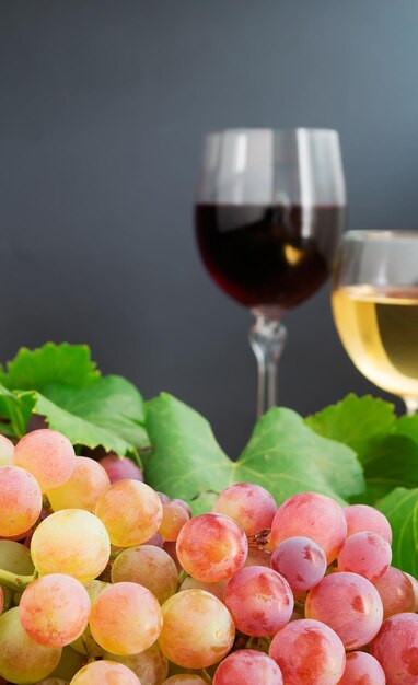 Uva com duas taças de vinho ao fundo