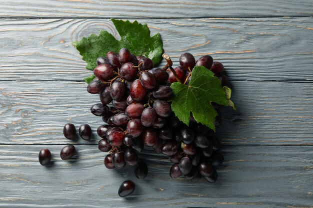 Uva madura fresca con hojas de madera gris