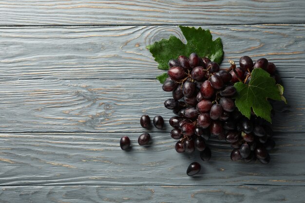 Uva madura fresca con hojas de madera gris