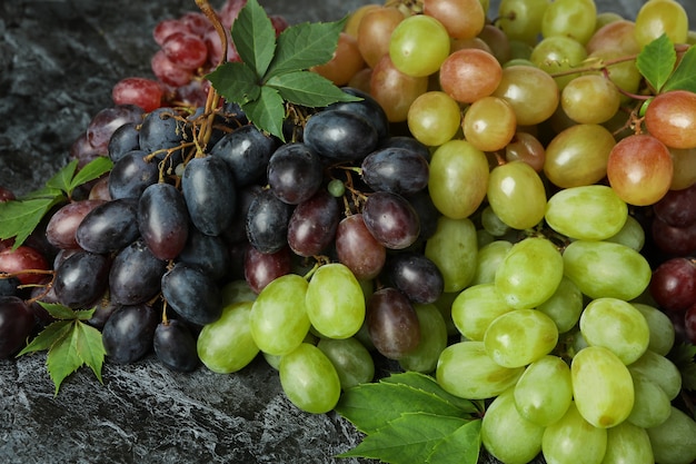 Uva madura y hojas sobre fondo negro ahumado