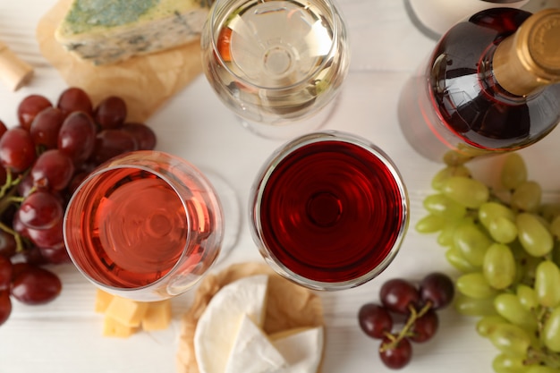 Uva, queijo, garrafa e copos com vinho branco