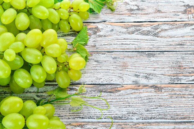 Uva Uvas blancas frescas sobre un fondo de madera blanca Vista superior Espacio libre para texto