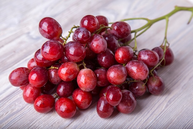 Uva vermelha em uma mesa de madeira. Fruta fresca