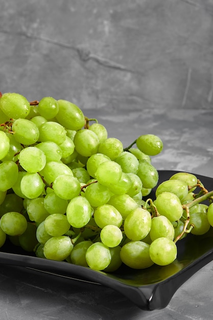 Uvas blancas dulces maduras sobre un fondo gris de hormigón