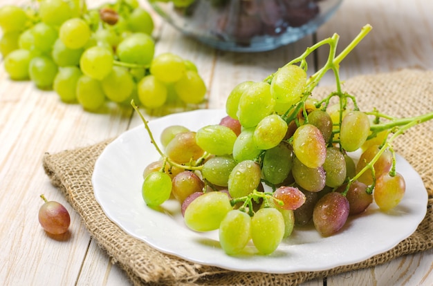 Uvas blancas en plato blanco.