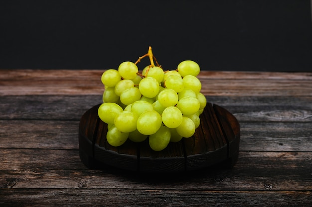 Uvas blancas en una tabla de madera