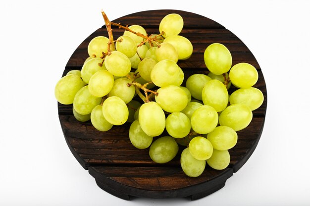 Uvas blancas en una tabla de madera