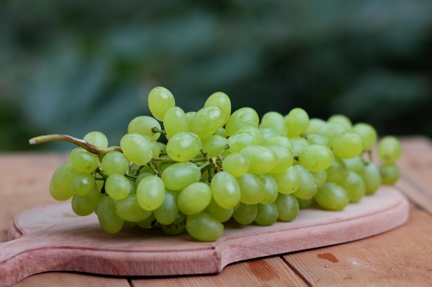Uvas brancas maduras em uma placa de madeira Shine Muscat Grape em fundo desfocado na mesa de madeira Closeup