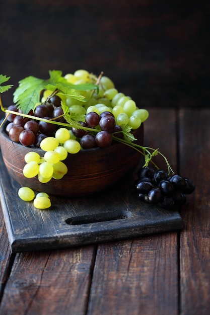 Uvas en un cuenco de madera, bodegón rústico