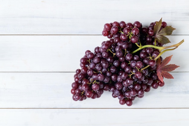 Uvas de champanhe no fundo branco de madeira Conceito de frutas