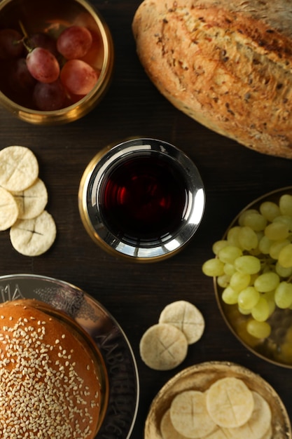 Uvas de pão em tigelas e copo de vinho em fundo de madeira vista superior