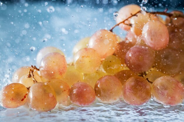 Foto uvas em gotas e salpicos de água caindo