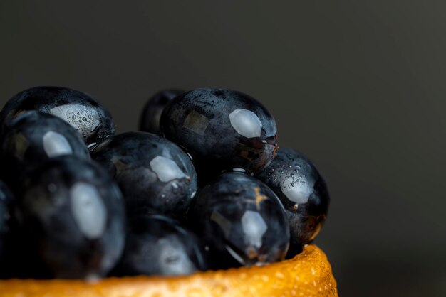 Foto uvas frescas mojadas de color azul cocinadas con uvas frescas dulces y bayas azules con gotas de agua