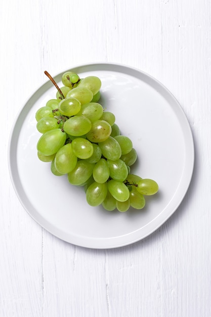 Uvas frescas de temporada en plato de plástico