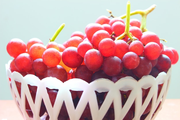 Uvas frescas vermelhas na cesta branca