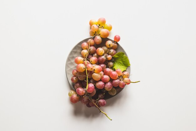 Uvas isoladas. uva vermelha em uma tigela isolada no fundo branco
