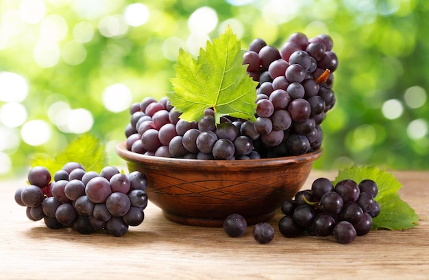 Uvas maduras frescas con hojas en un bol