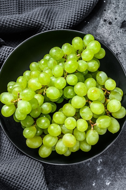 Uvas maduras verdes en un plato, frutos de otoño.