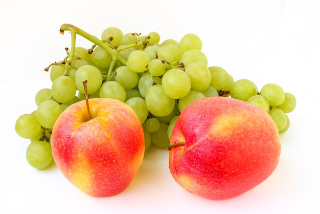 Uvas y una manzana sobre un blanco