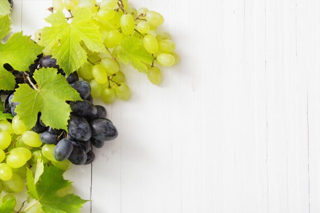 Uvas en mesa de madera blanca