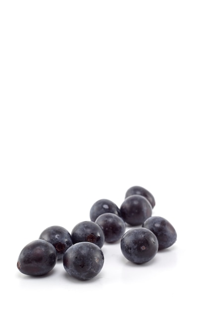 Uvas negras frescas en blanco