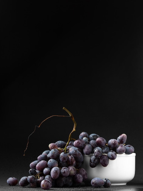 Uvas oscuras maduras en el espacio de copia de fondo oscuro