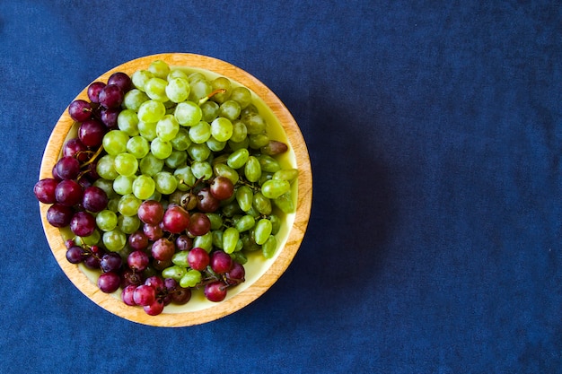 Uvas de otoño en la mesa azul, cosechando fruta de temporada