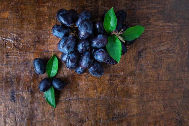 Uvas pretas em uma cesta em uma mesa de madeira