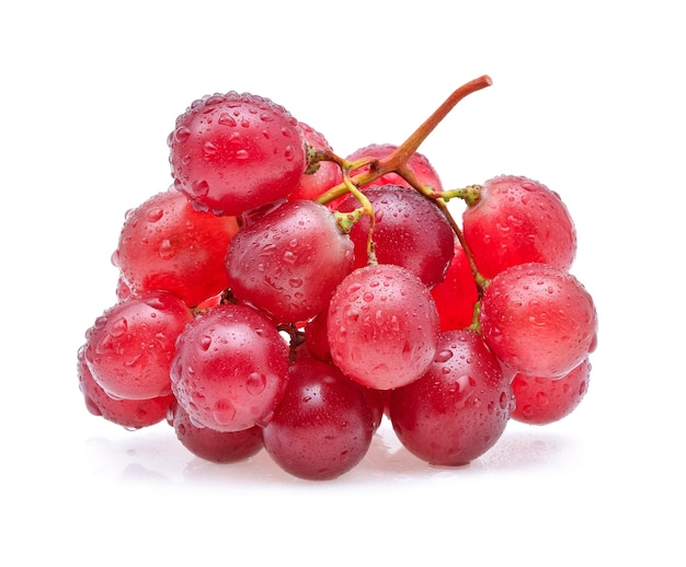 Uvas rojas y gotas de agua aisladas en blanco