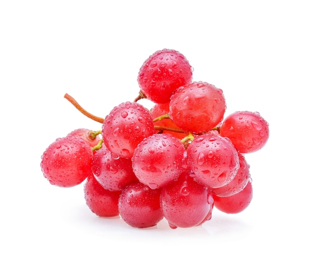 Uvas rojas y gotas de agua aisladas en blanco