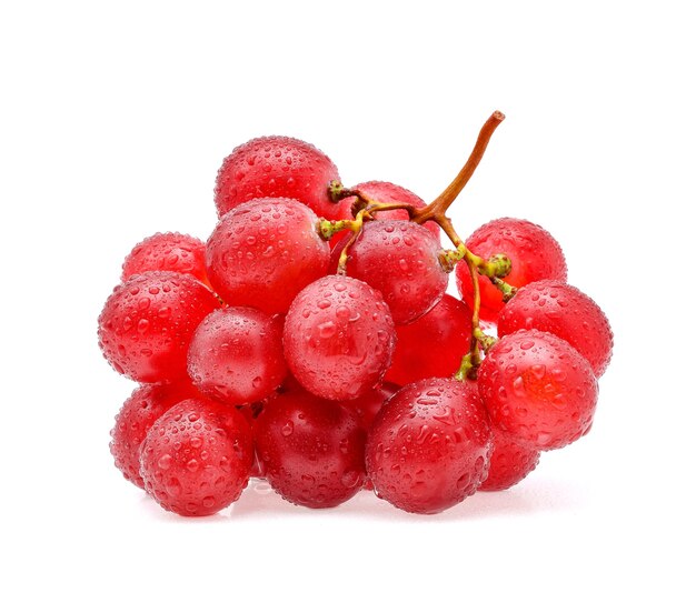 Uvas rojas y gotas de agua aisladas en blanco