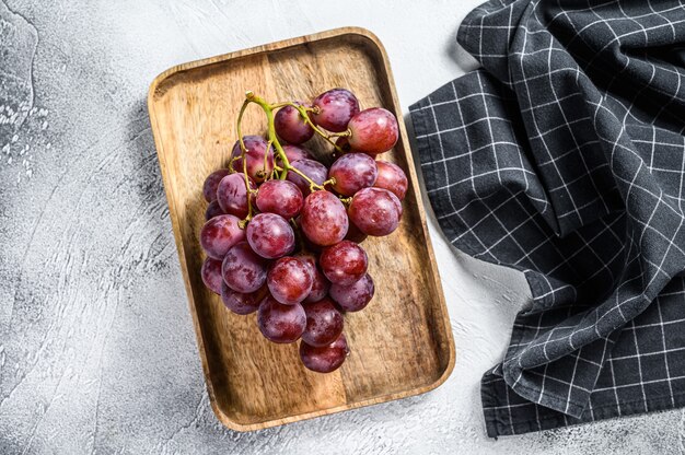 Uvas rojas maduras en un cuenco de madera