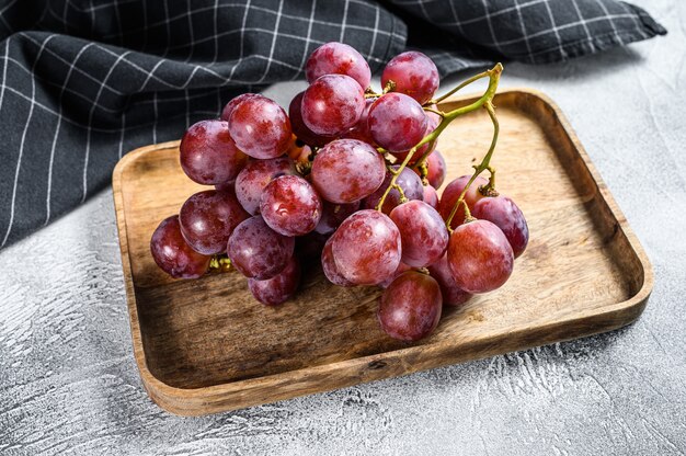 Uvas rojas maduras en un tazón de madera. Vista superior