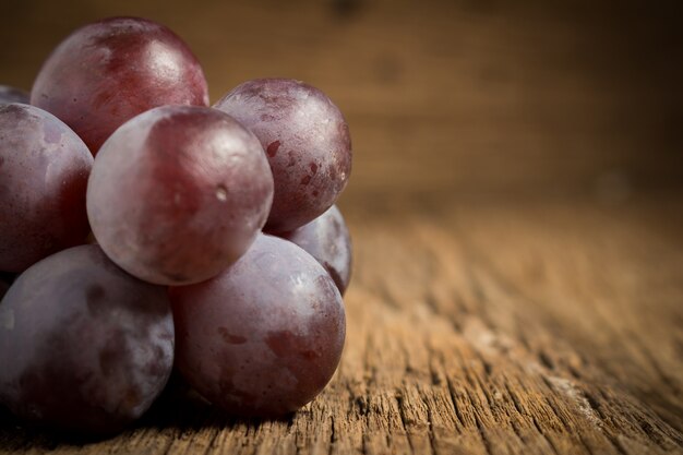 Uvas rojas en mesa de madera