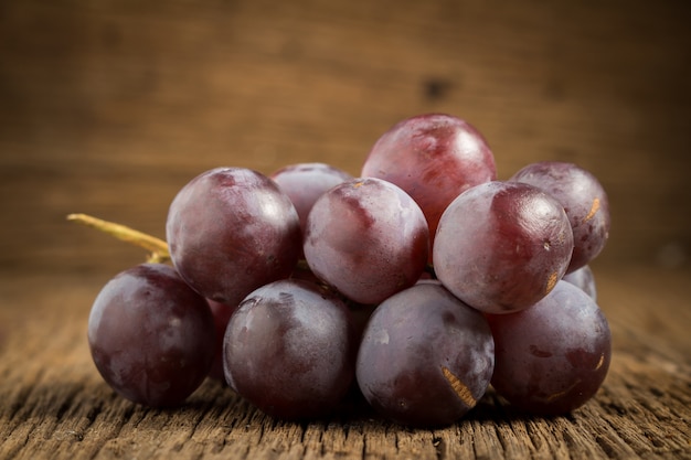 Uvas rojas en mesa de madera