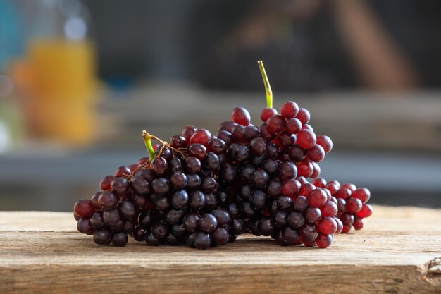 Uvas rojas en una mesa de madera