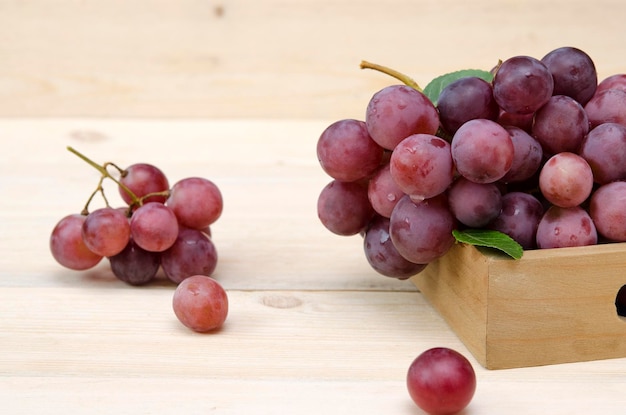 Uvas rosadas maduras en una caja de madera de cerca