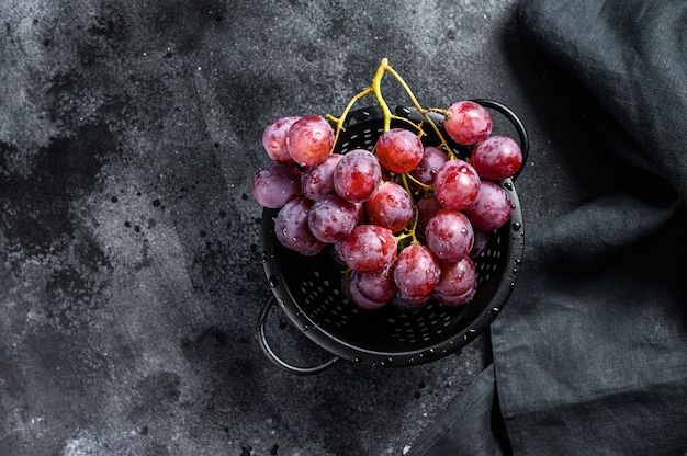 Uvas rosadas maduras en un colador