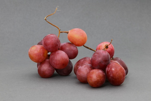 Uvas rosas en un plato con gotas de agua